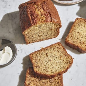 a loaf of banana bread sliced on marble table