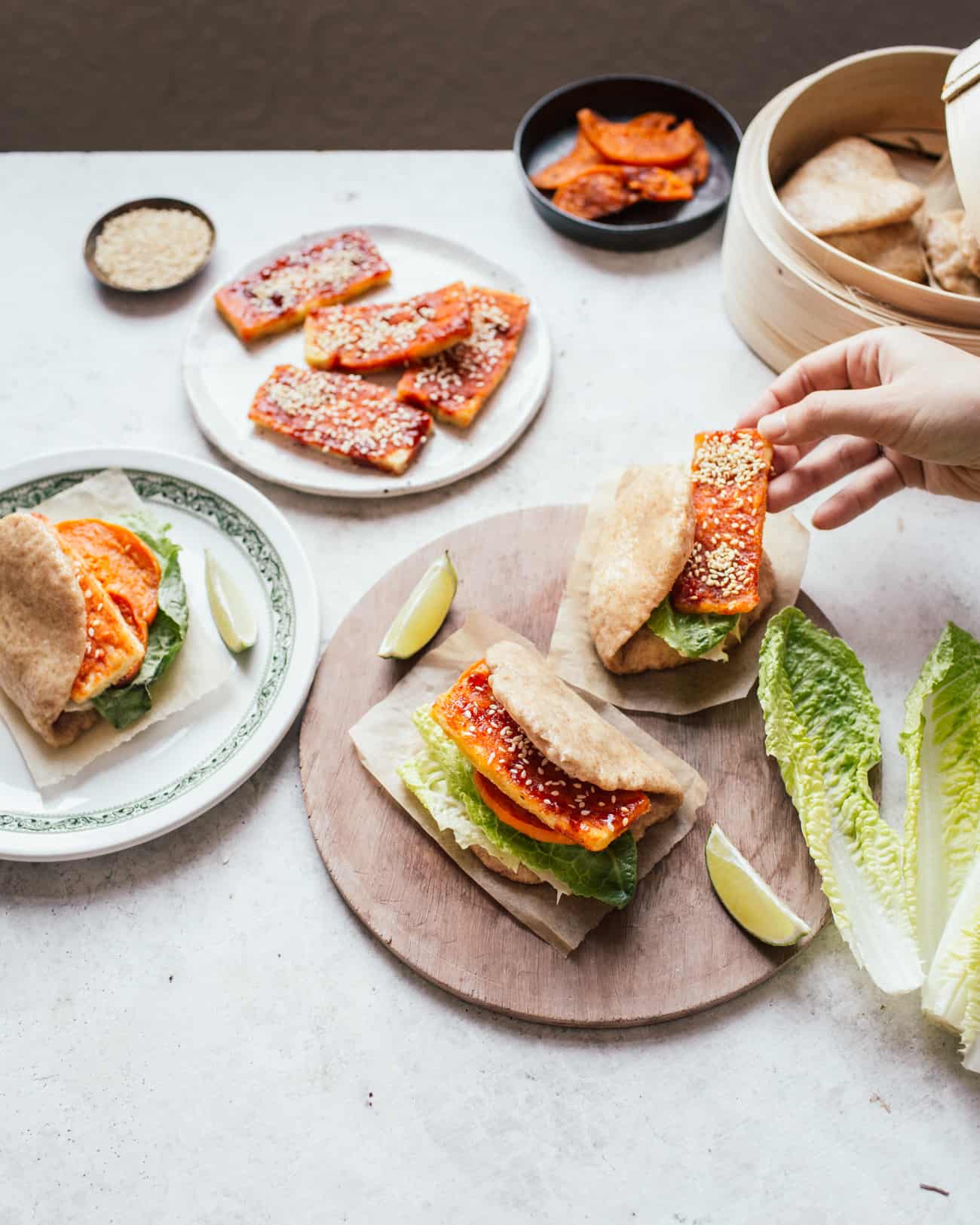 Assembling Bao buns filled with crispy gochujang tofu, lettuce and butternut squash