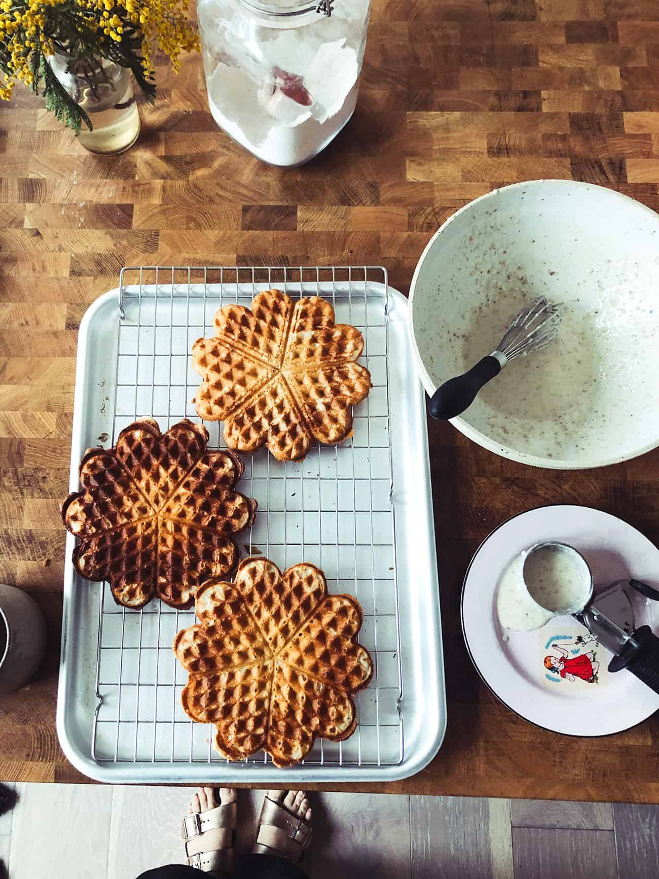 a tray of vegan waffles and a bowl of waffle batter on a counter top