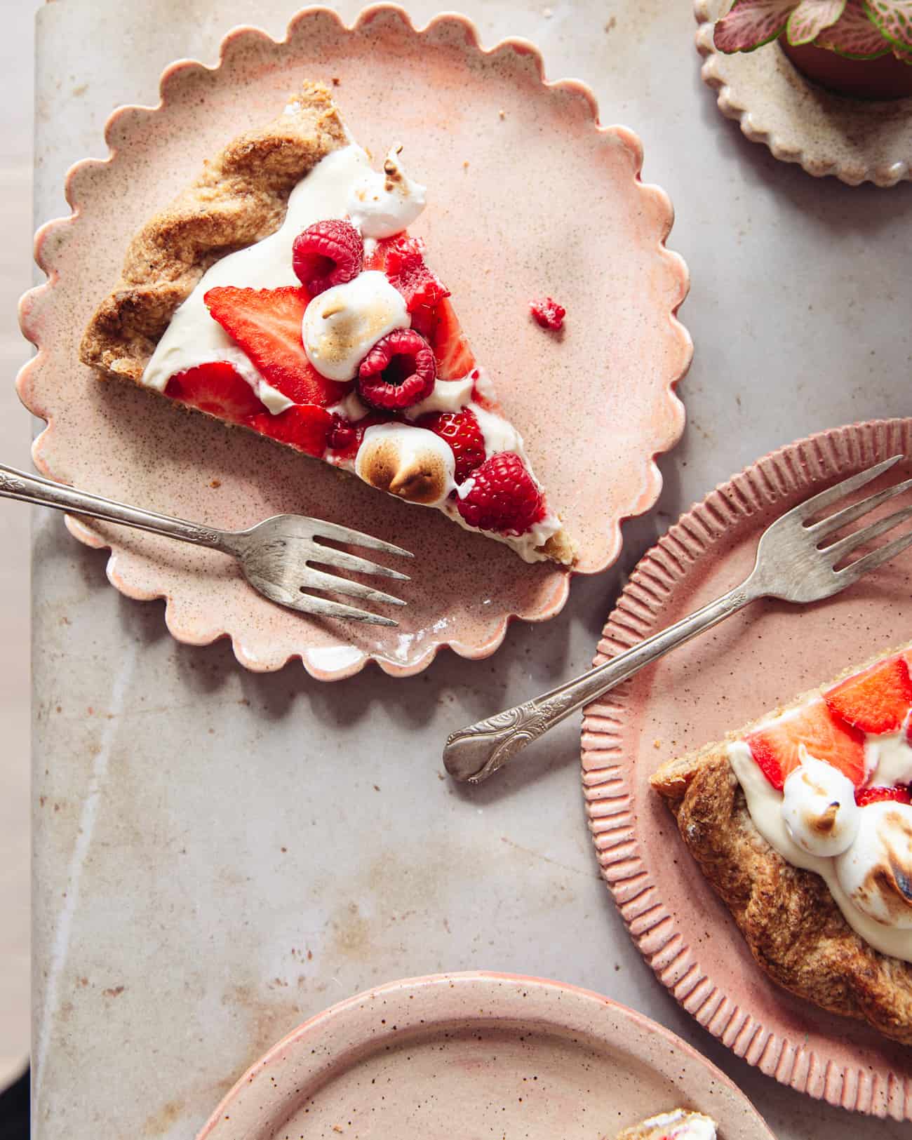 A slice of Eton mess tart on a pink scalloped plate