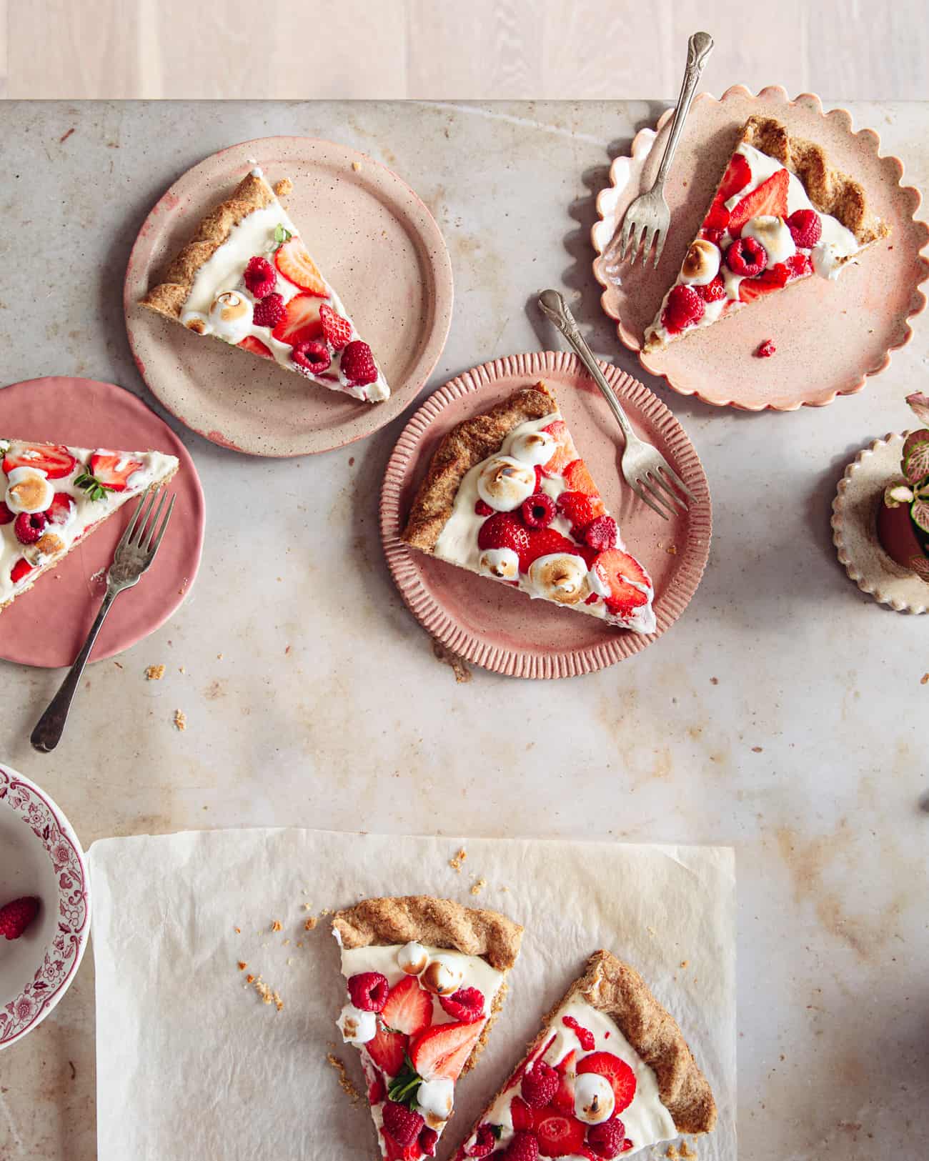 Multiple slices of eton mess tart on pink plates