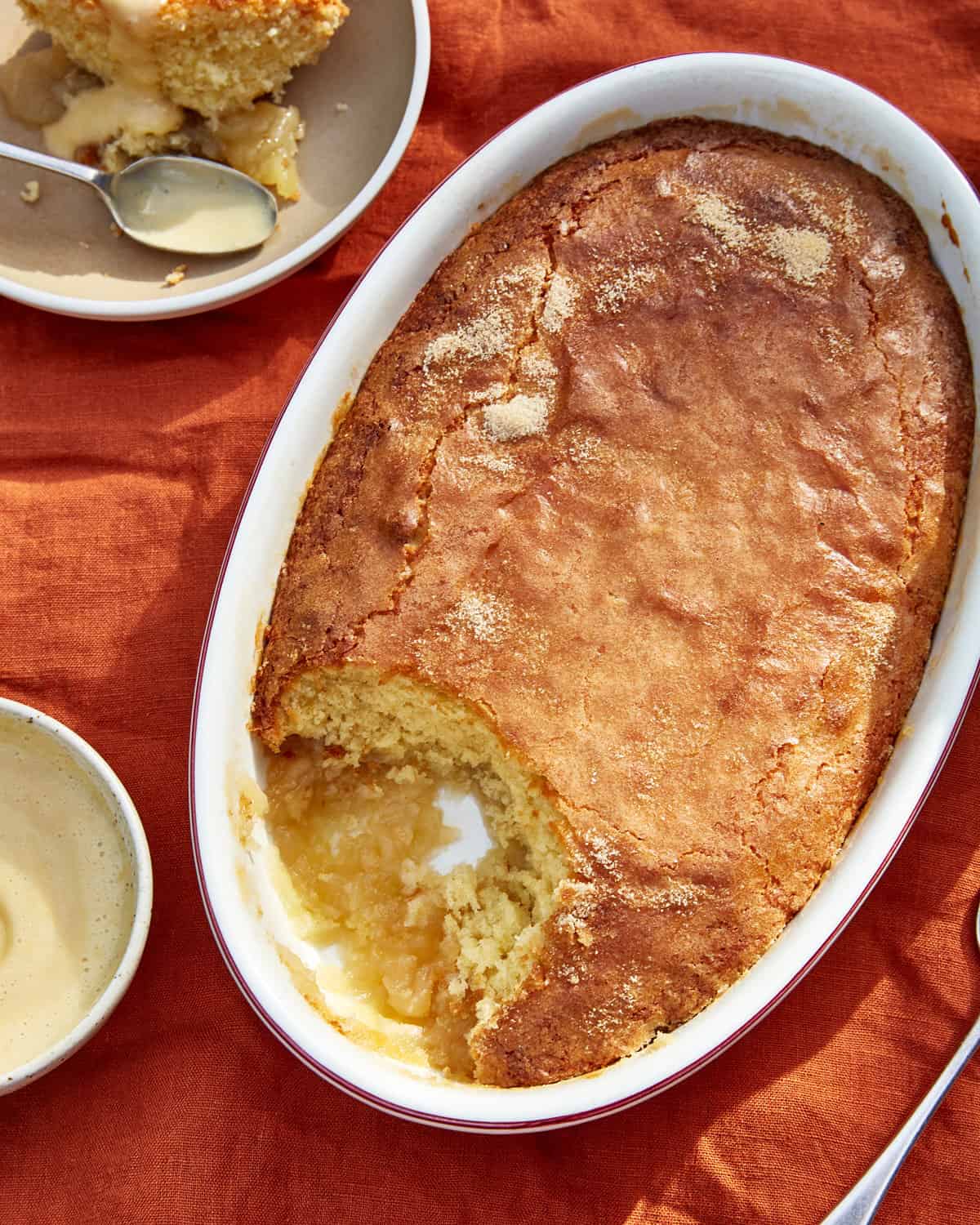 closeup of Eve's pudding with a scoop taken on orange cloth