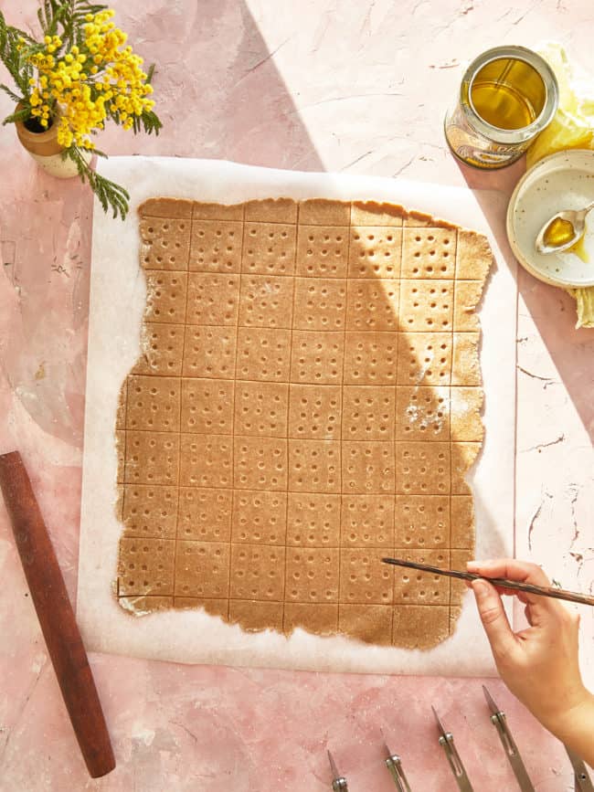 docking graham cracker dough with a chopstick