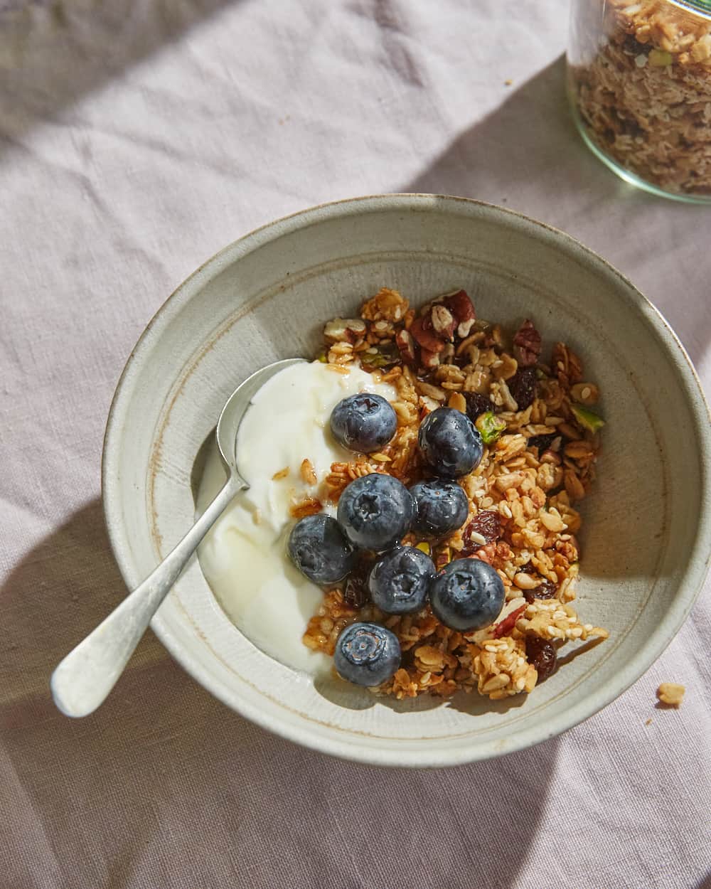 a bowl of crunchy vegan granola with soy yoghurt & blueberries