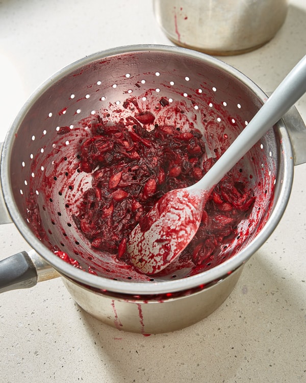 damson pits and skins remaining in colander