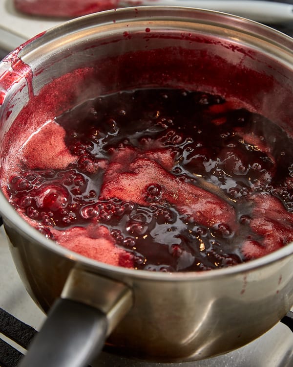 damson jam cooking with glossy bubbles forming