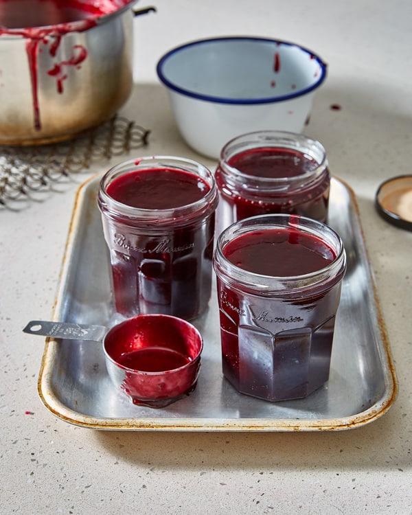 damson jam in jars with pot of jam in background