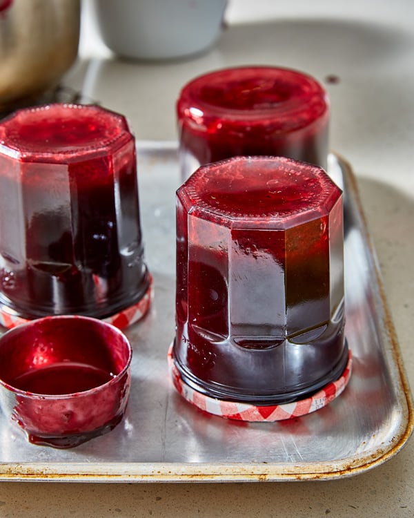 jars of damson jam upside down on a tray