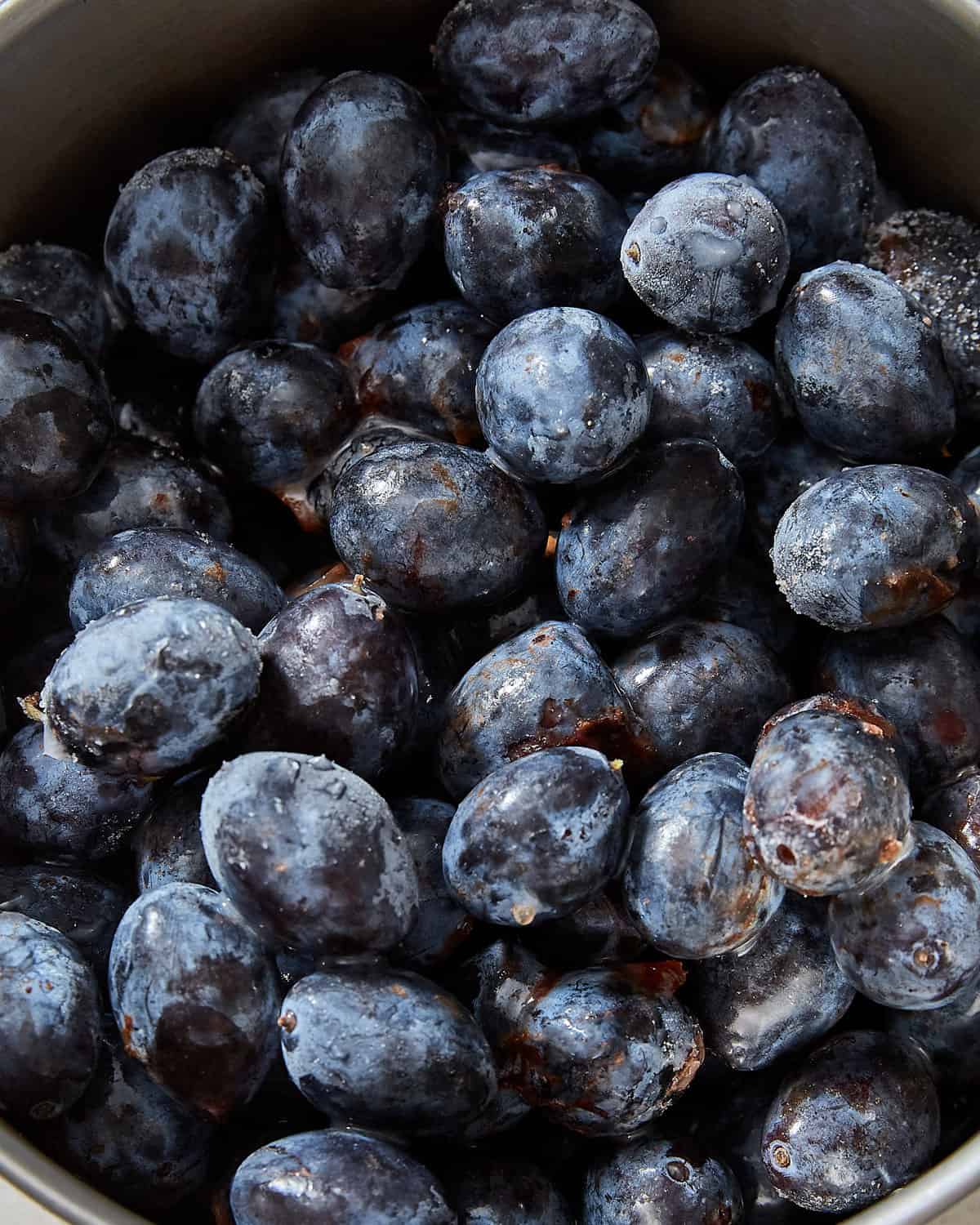 a closeup image of frozen damsons in a pot