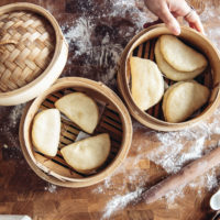 Steamed gua bao buns in a bamboo steamer