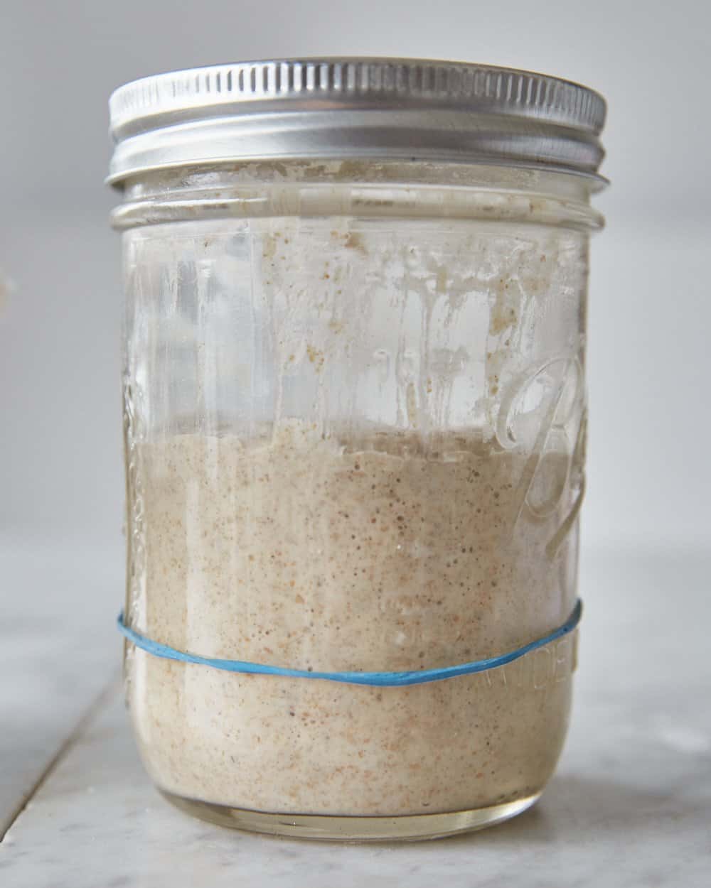 a fully risen sourdough starter in a jar