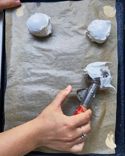 using ice cream scoop to transfer meringue to baking tray