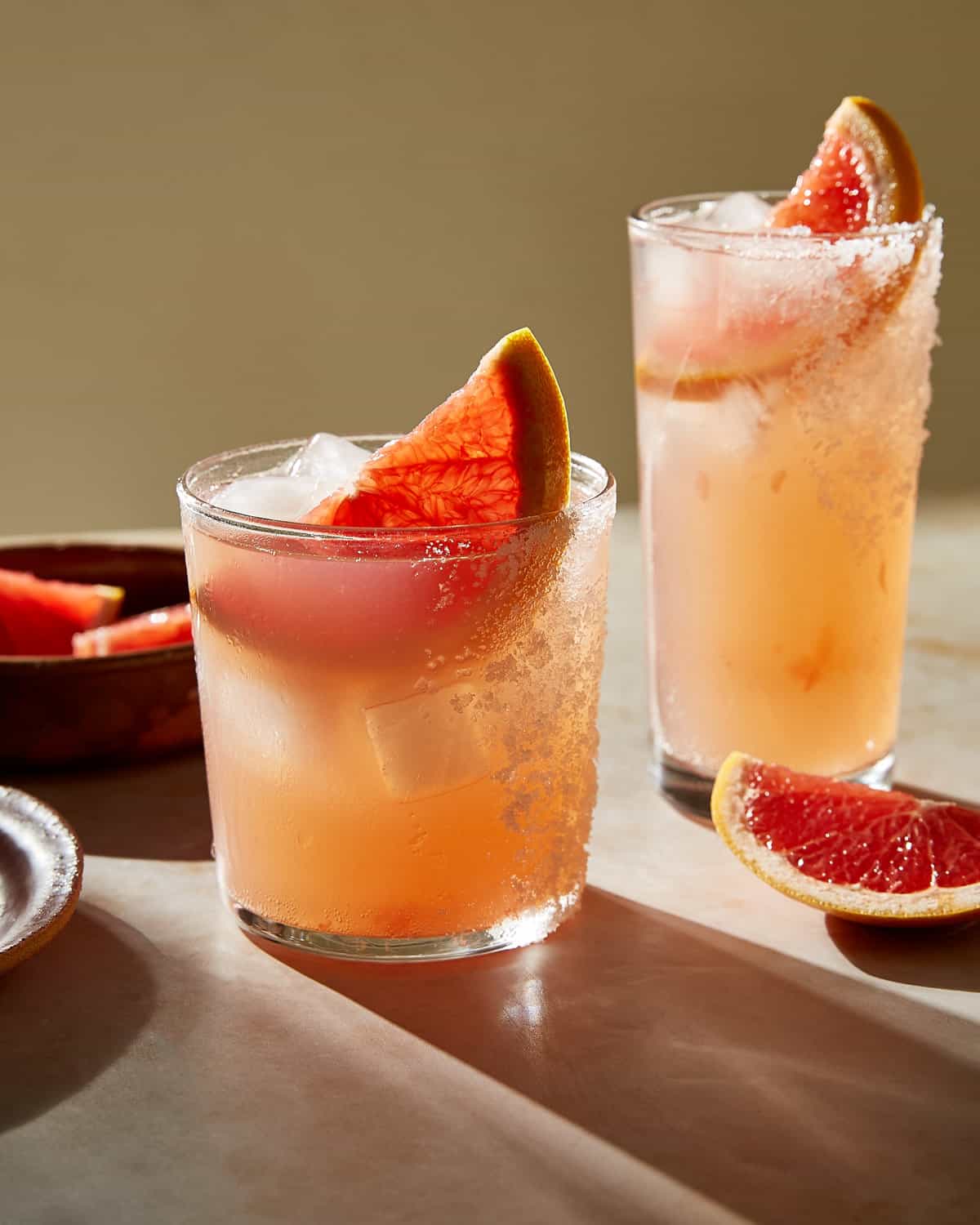 two glasses of Paloma cocktail with salted rim and slice of grapefruit garnish