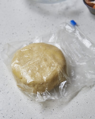 a disk of shortcrust pastry in a ziplock bag on a countertop