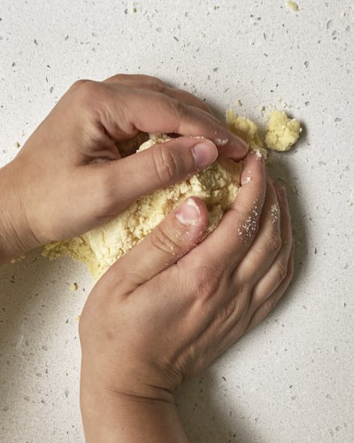 brining shortcrust pastry dough together on work surface