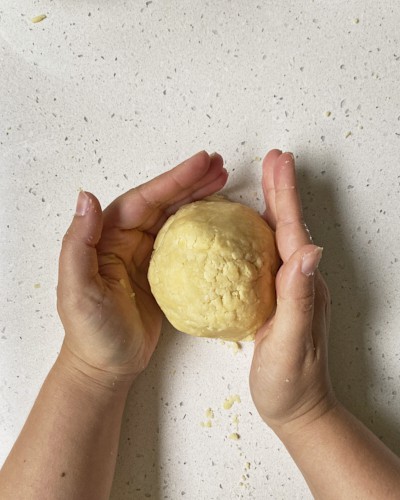 shortcrust pastry ball on the counter with hands