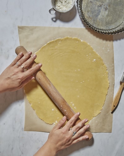 rolling out shortcrust pastry on baking paper