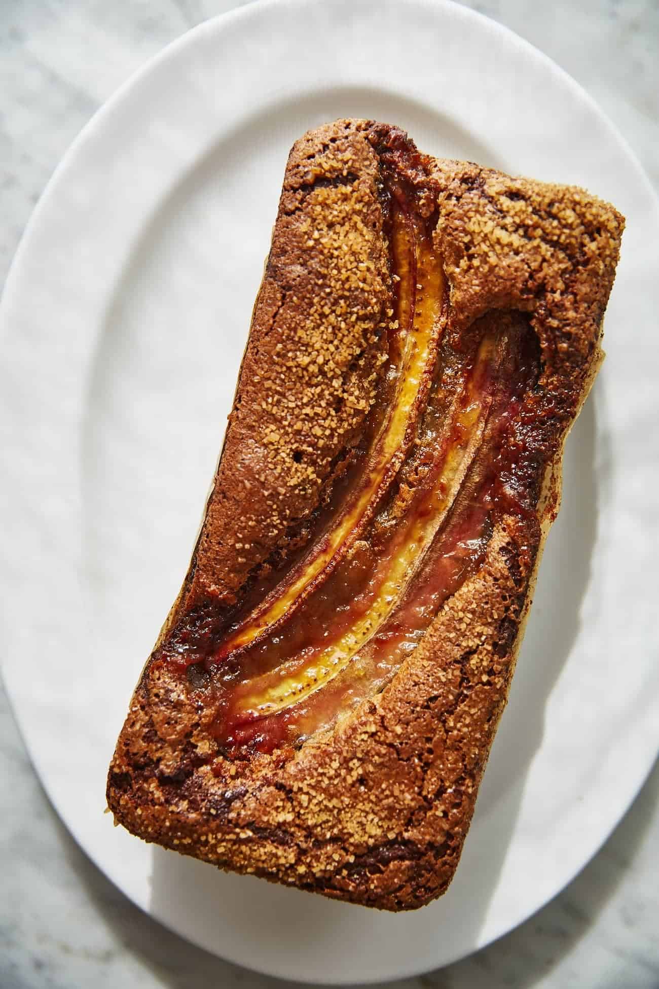 a loaf of vegan sourdough banana bread on an oval plate