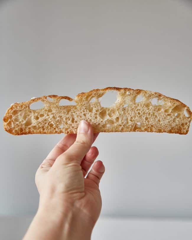 holding a slice of sourdough focaccia