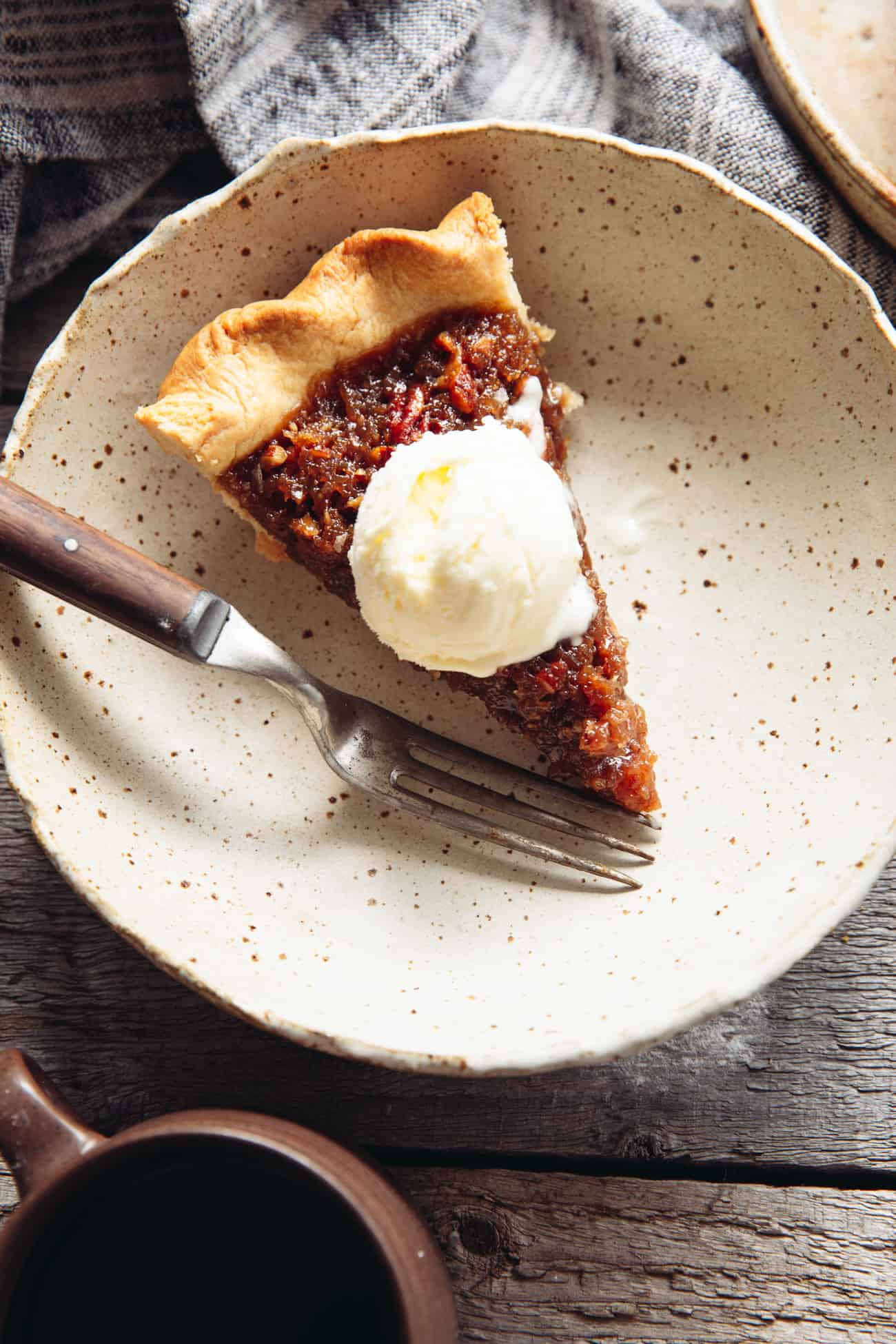 a slice of vegan maple pecan pie with ice cream