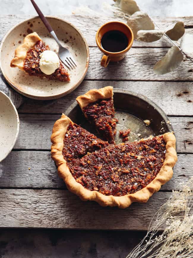 pie tin with vegan maple pecan pie and a slice taken out