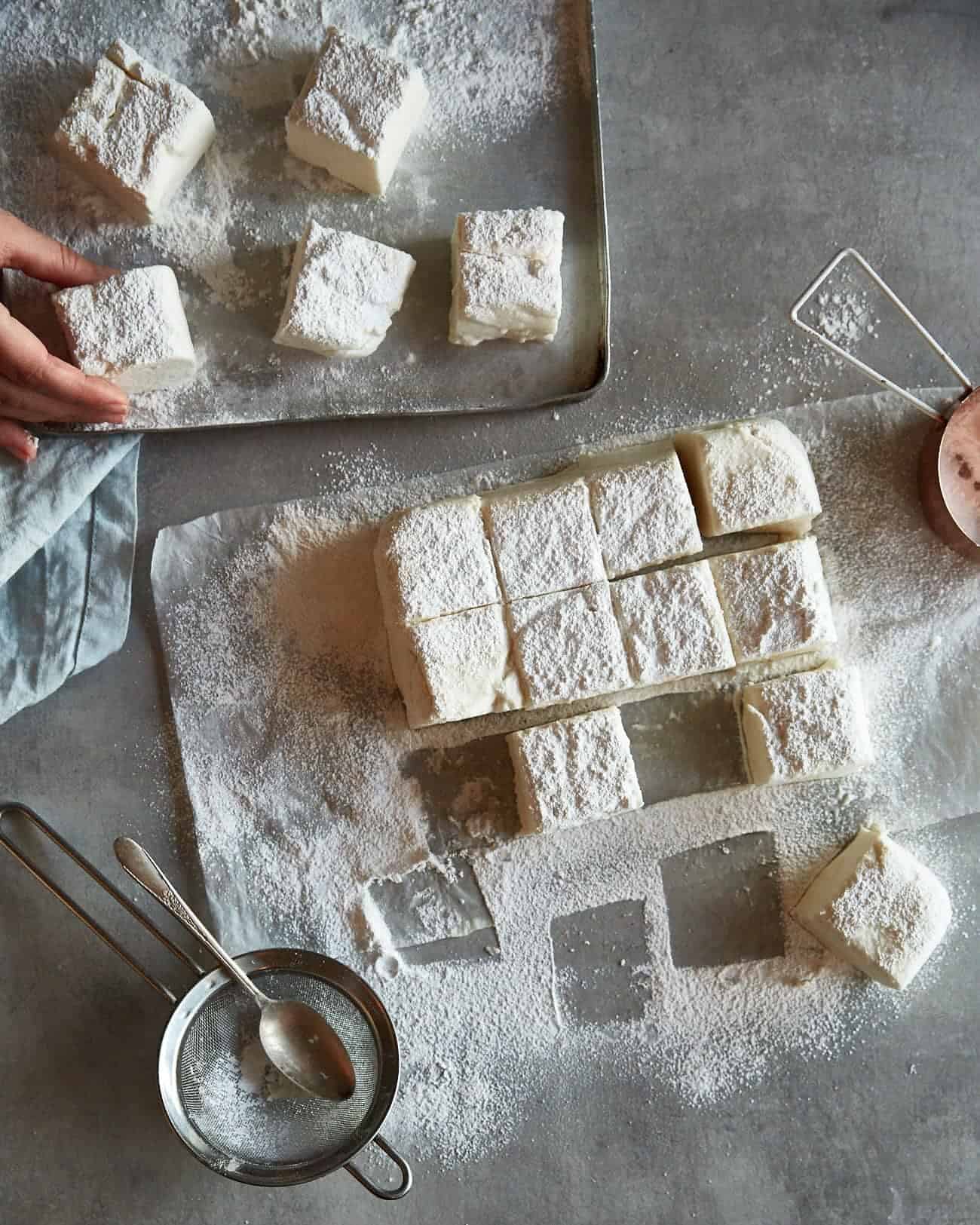 some cut vegan marshmallows on a worktop and on a baking sheet